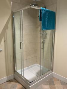 um chuveiro com uma porta de vidro na casa de banho em Wheldale Hotel em Castleford