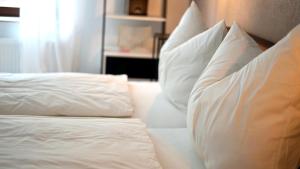 Lehmen的住宿－Casa Mo - Ferienwohnung Lehmen，床上铺有白色枕头的床