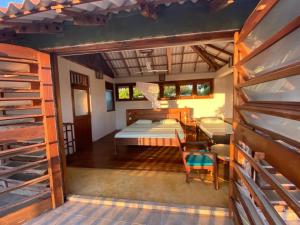 a room with a bed and bunk beds in it at Kudakalliya Beach Houses in Arugam Bay