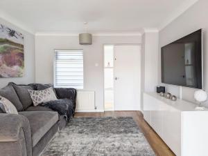 a living room with a couch and a flat screen tv at Brook House - Emsworth in Emsworth
