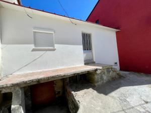 un edificio blanco con una pared roja y blanca en Casinha no caminho de Santiago, en Belinho