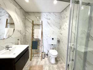 a bathroom with a toilet and a sink and a shower at Casinha no caminho de Santiago in Belinho