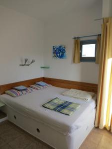 - une chambre avec un grand lit blanc et une fenêtre dans l'établissement Ferienhaus Felix mit Meerblick, à Pollonia