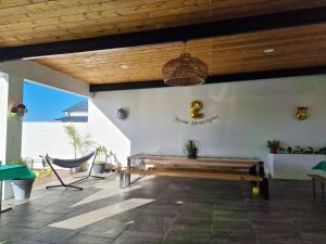 een patio met een bank en een bord aan de muur bij Villa Ô Bel Air - 4 étoiles - détente au bord de la piscine et baby-foot ! in Saint-Joseph