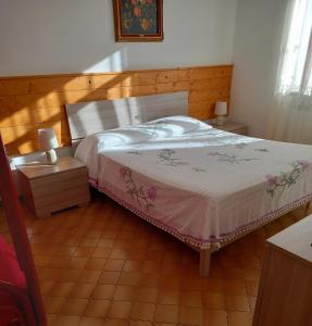 una camera da letto con un letto e due comodini di BELLAVISTA - Appartamenti sul Lago di Scanno a Scanno