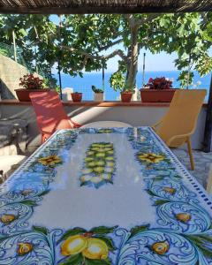 a table with a colorful table cloth on it at La Sciuscella in Conca dei Marini