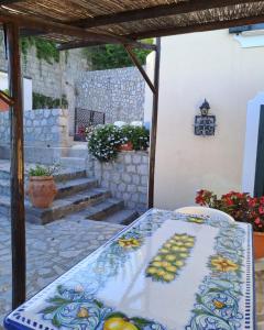a table with a blue and white table cloth on a patio at La Sciuscella in Conca dei Marini