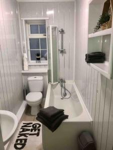 a bathroom with a tub and a toilet and a sink at House near city centre in Hull