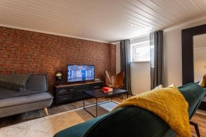 a living room with a couch and a brick wall at Harley in der Heide in Buchholz Aller