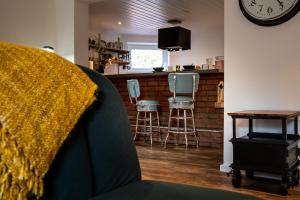 布赫霍尔茨Harley in der Heide的带时钟的客厅和带凳子的厨房