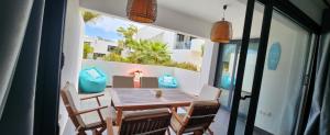 un balcone con tavolo e sedie in legno su un patio. di Beach Life a Villaverde