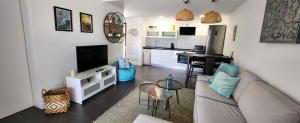 a living room with a couch and a tv and a kitchen at Beach Life in Villaverde