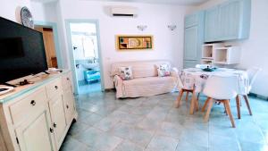un soggiorno con tavolo e divano di Appartamento La Terrazza - Località Cala Gavetta a La Maddalena