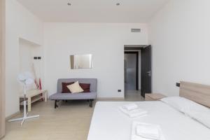 a white room with a bed and a chair at I Host Apartment - Asiago 4 in Milan