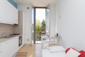 a kitchen with a white couch and a table in a room at I Host Apartment - Asiago 4 in Milan