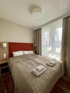 a bedroom with a bed with two towels on it at Bel Mare Aqua in Międzyzdroje