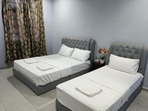 two twin beds in a room with a window at The Marak Village KB - Mini Homestay in Kota Bharu