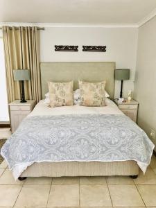 um quarto com uma grande cama branca e 2 candeeiros em 10VDW Self Catering Apartments em Durbanville