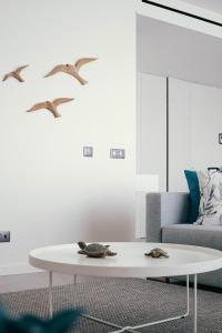 a living room with a white coffee table and birds at Orange Boutique Residence - Casa Diogo in Quarteira