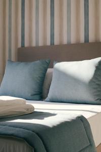 a bed with blue and white pillows on it at Orange Boutique Residence - Casa Diogo in Quarteira