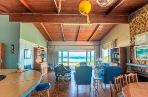 a living room with blue chairs and a table at Anna's On The Beach in Cape St Francis