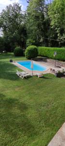 einen Pool im Garten mit Stühlen und Bäumen in der Unterkunft Le gîte du moulin au fil de l eau 