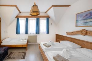 a bedroom with two beds and a ceiling at Waldschlössl Gasthof in Sankt Lorenzen ob Murau