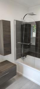 ein Badezimmer mit einer Badewanne, einem Waschbecken und einem Spiegel in der Unterkunft Le gîte du moulin au fil de l eau 