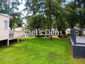 a yard with a sign that reads deliths den at Del's den lakeside weeley bridge in Weeley