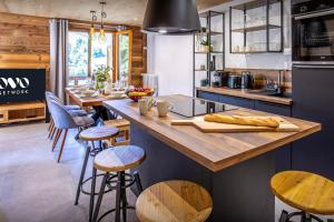 una cocina con una gran isla con taburetes de bar en Loft Monte Clusio - OVO Network en La Clusaz