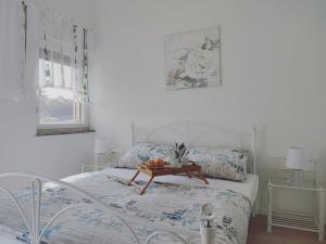 a white bedroom with a bed with a tray of fruit on it at Secret Garden Villa in Matulji
