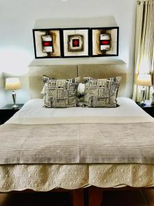 um quarto com uma cama com duas fotografias na parede em 10VDW Self Catering Apartments em Durbanville