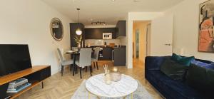 a living room with a blue couch and a table at Lamberts House - 2 Bed, 2 Bathroom in Leeds