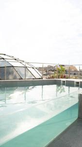 una piscina de agua con un edificio al fondo en Gran Hotel Havana 4Sup by Escampa Hotels, en Barcelona