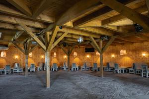 a large room with chairs and tables and wooden ceilings at Dolphin Camping in Sfântu Gheorghe