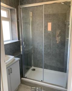 a bathroom with a shower with a glass door at Large 2-bedroom maisonette with free parking in Twickenham