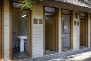 a building with four glass doors and a sink on it at Dolphin Camping in Sfântu Gheorghe +246 photos