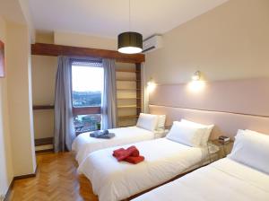 um quarto com três camas com lençóis brancos e uma janela em LV Premier Apartments Clerigos- RE1 no Porto
