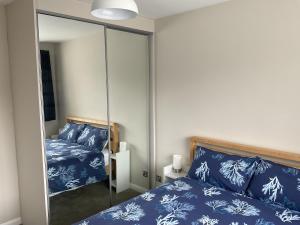 una camera da letto con specchio accanto a un letto di Large 2-bedroom maisonette with free parking a Twickenham