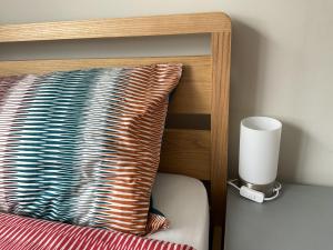 un testiera in legno con cuscino e lampada di Large 2-bedroom maisonette with free parking a Twickenham