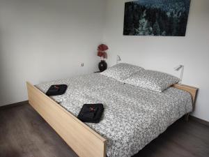 a bedroom with a bed with two black shoes on it at Ferienwohnung Schwarzwald Oase Kniebis in Kniebis