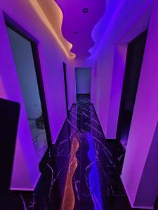 an empty room with purple lights on a tile floor at Aleksandro&Michell in Rijeka