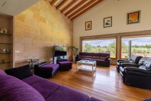 een woonkamer met paarse banken en een tv bij La Forca in Santa Margalida