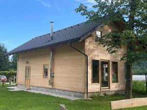 ein kleines Holzhaus mit schwarzem Dach in der Unterkunft ABC Apartma Kočevsko in Kočevje