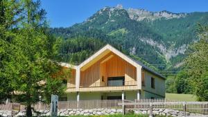 une maison avec une clôture en face d'une montagne dans l'établissement Da Alois, à Gröbming