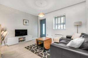 a living room with a couch and a tv at Stylish 1 Bedroom Apartment in Central Woking in Woking