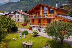 a large wooden house with a table and chairs at Les Moulins D'Angelina - OVO Network in Séez