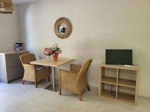 een kamer met een tafel met stoelen en een televisie bij La villa Roméo in Sainte-Maxime