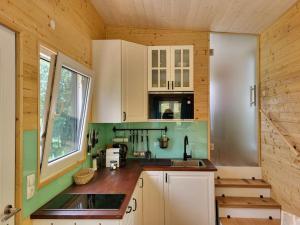 a kitchen with white cabinets and a sink at Tinyhaus Villa to go in Reichenau