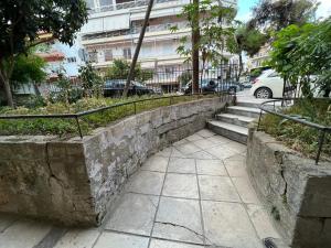 a stone retaining wall with stairs and a railing at Cozy Corner in Alexandroupoli
